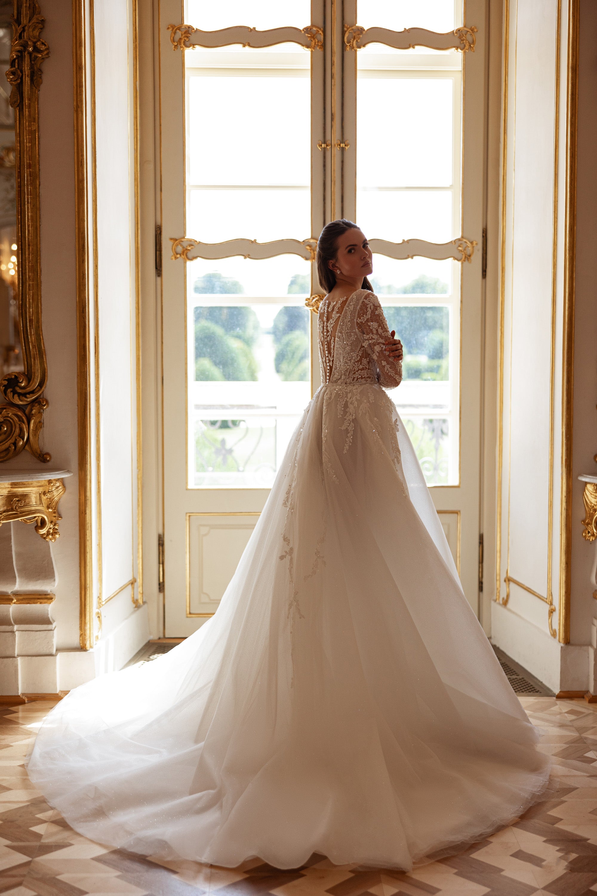 Long-train ivory wedding dress with a lace bodice, long sleeves, and a sweeping full A-line skirt