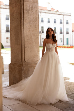 Ivory wedding dress with a beaded sweetheart bodice, full A-line skirt, and long flowing train
