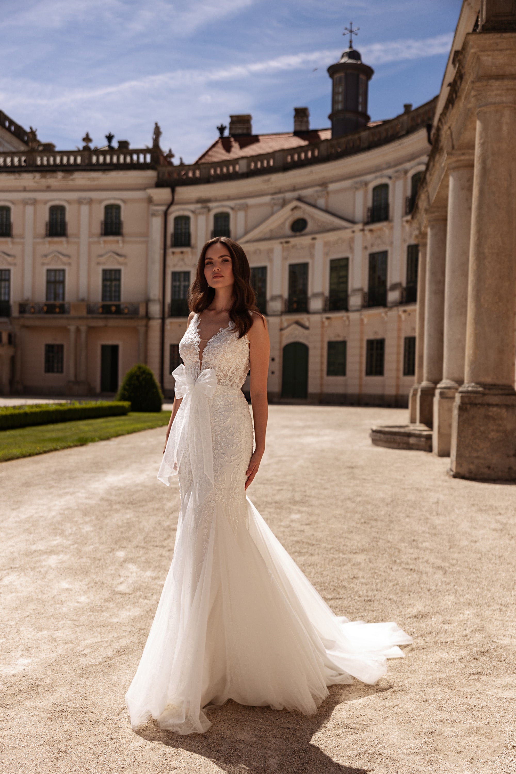 Ivory mermaid wedding dress with a deep V-neckline, beaded lace bodice, and flowing tulle train