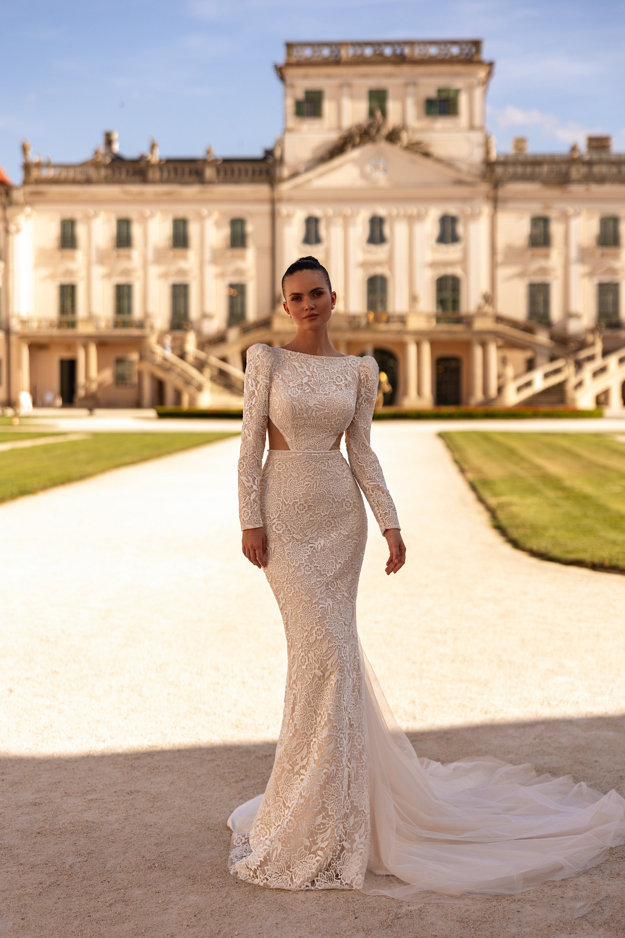 Ivory lace mermaid wedding dress with long sleeves, fitted bodice, and flowing tulle train