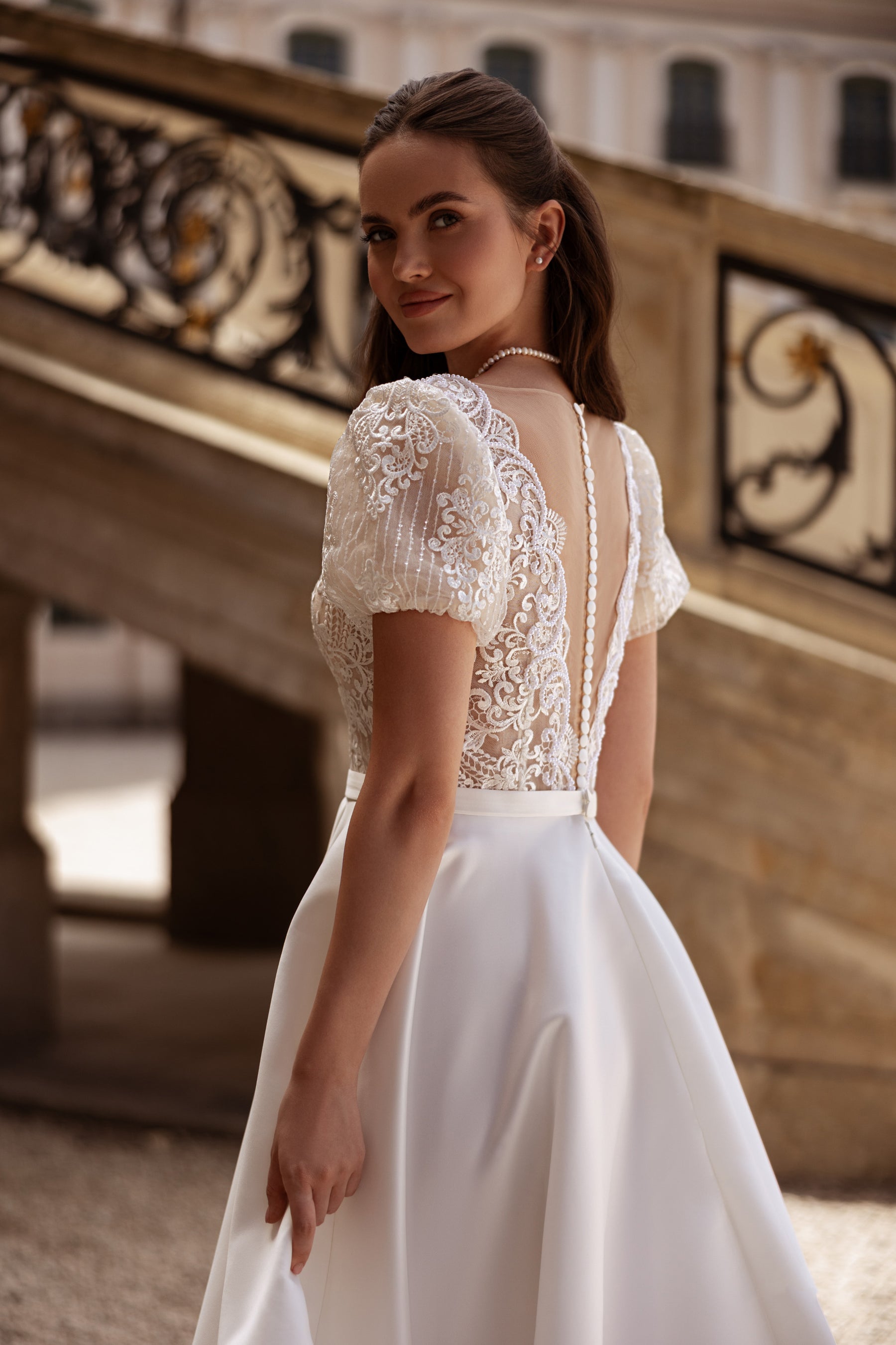 Ivory wedding dress showing a lace back with a narrow open center and flowing A-line skirt