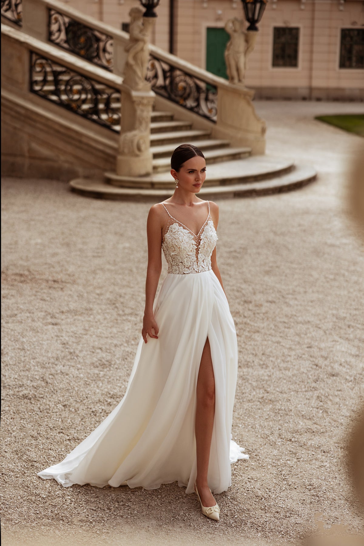 Ivory A-line wedding dress with floral lace bodice, spaghetti straps, thigh-high slit, and train
