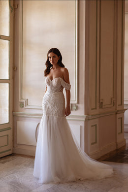 Full-length ivory mermaid wedding dress with off-the-shoulder sleeves, fitted lace bodice, and long train