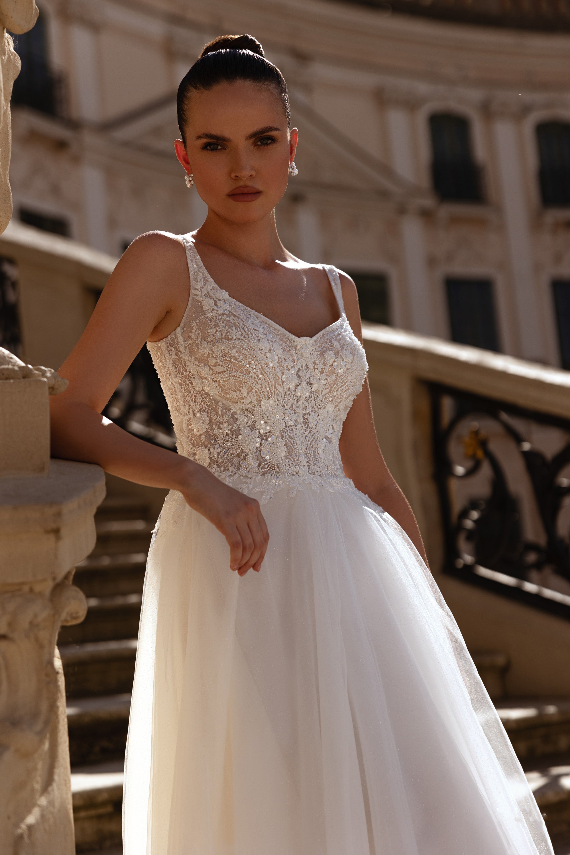 Close-up of an ivory wedding dress with a floral lace bodice, scoop neckline, and full tulle skirt