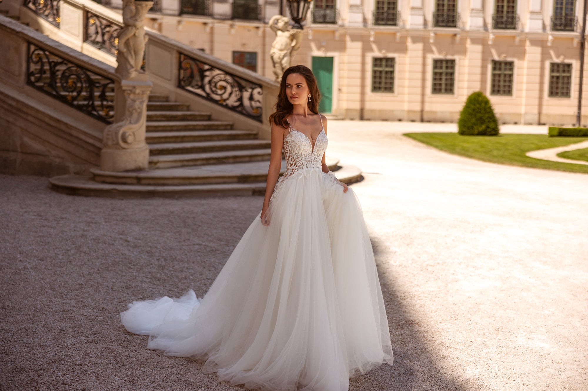 Full-length ivory A-line wedding dress with a floral lace bodice and flowing train