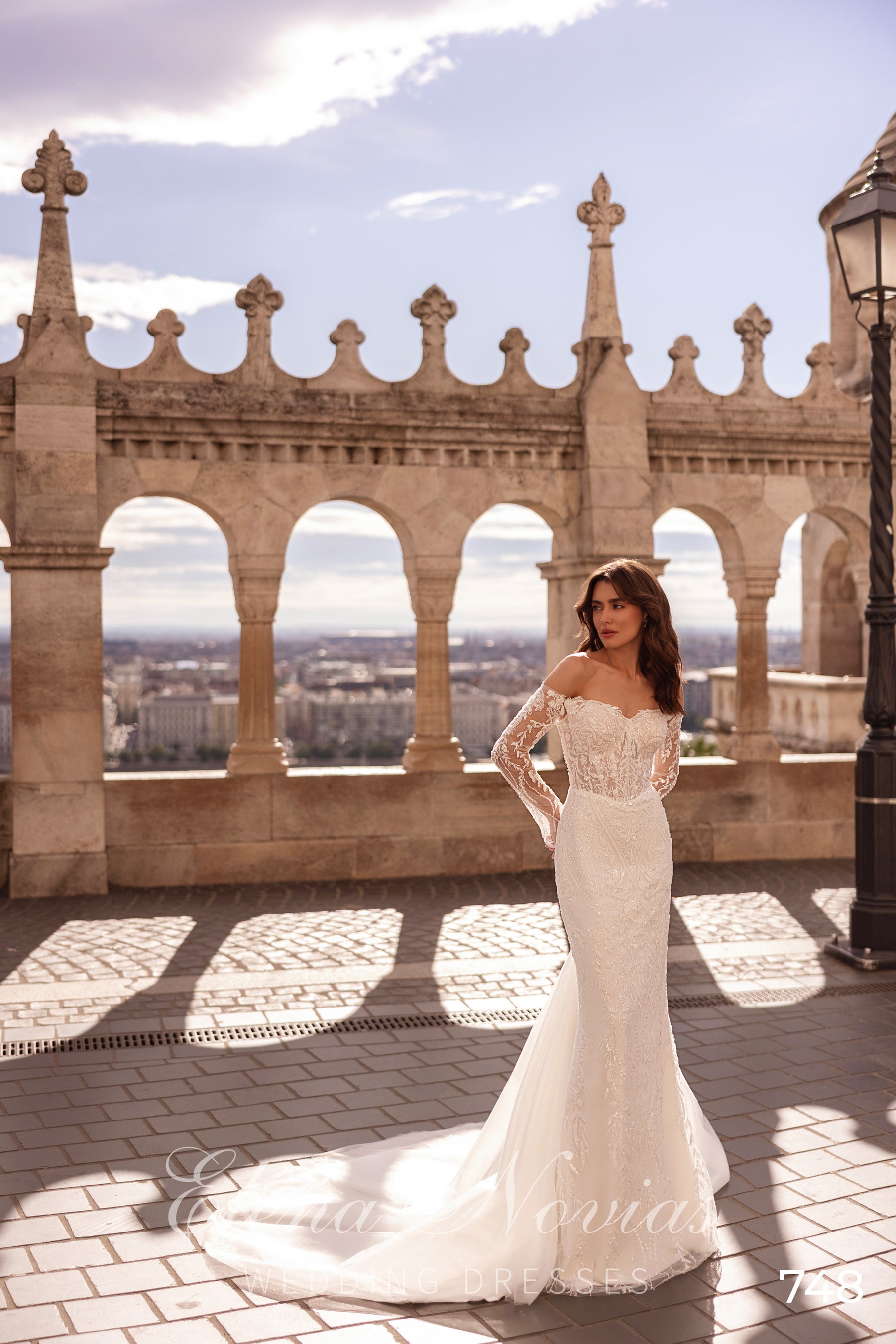 Ivory mermaid wedding dress with an off-the-shoulder lace bodice, long sleeves, and a sweeping train