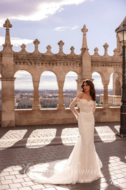 Ivory mermaid wedding dress with an off-the-shoulder lace bodice, long sleeves, and a sweeping train