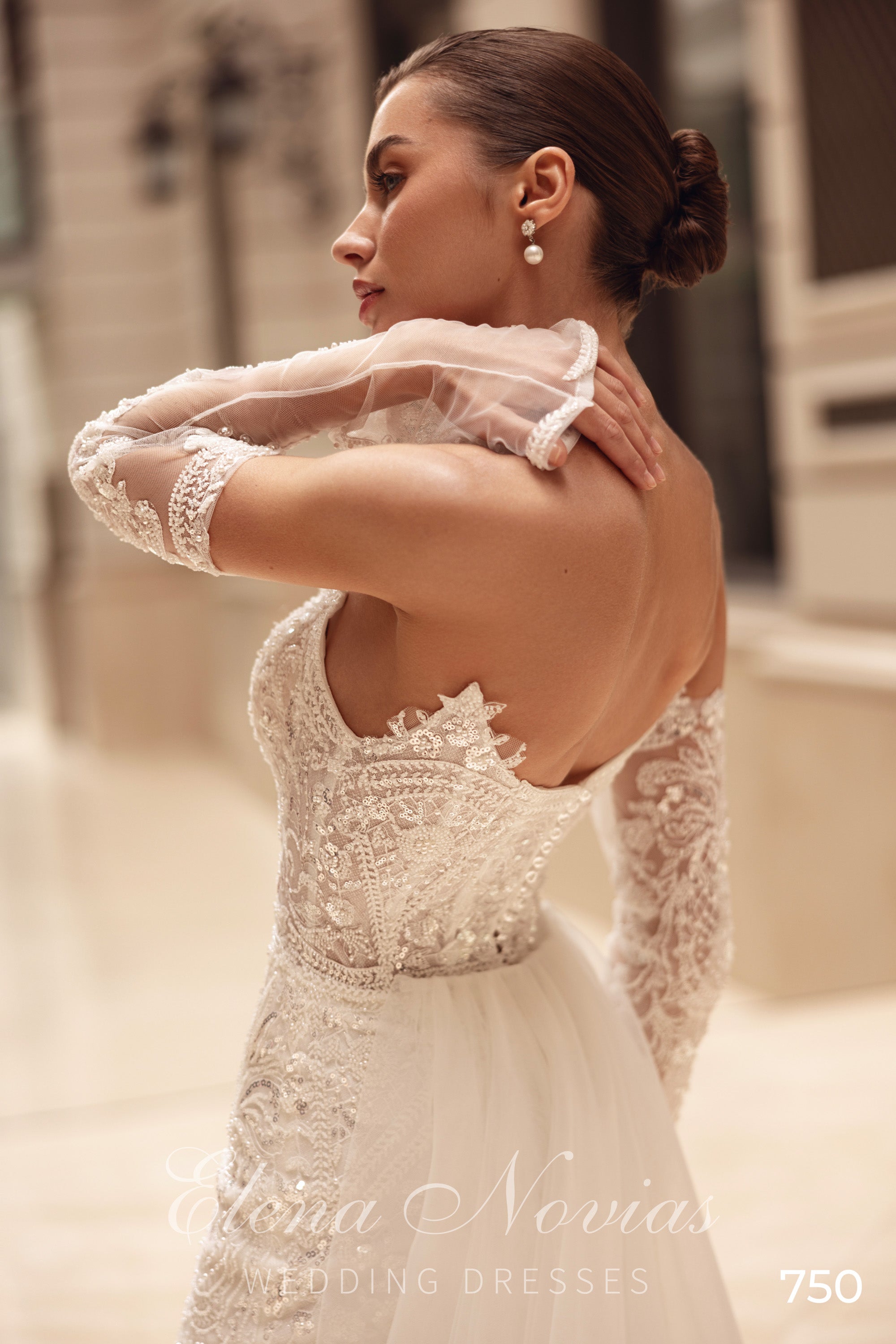 Close-up of the open back, beaded lace bodice, and sheer lace sleeves on an ivory wedding dress