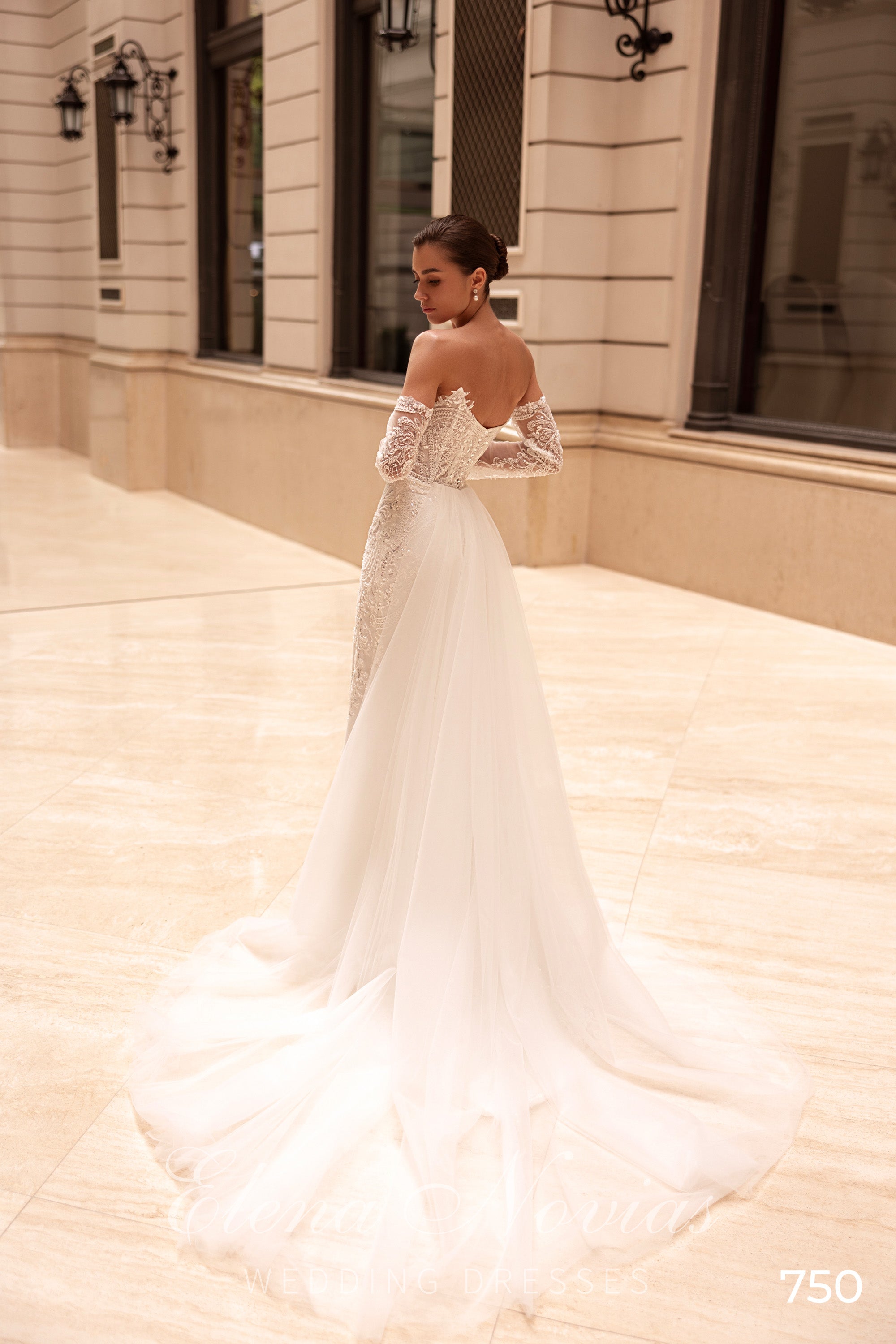 Open-back ivory mermaid wedding dress with lace sleeves and a flowing train