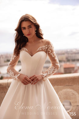 Ivory satin A-line wedding dress with a V-neckline, sheer floral lace sleeves, and beaded appliqués
