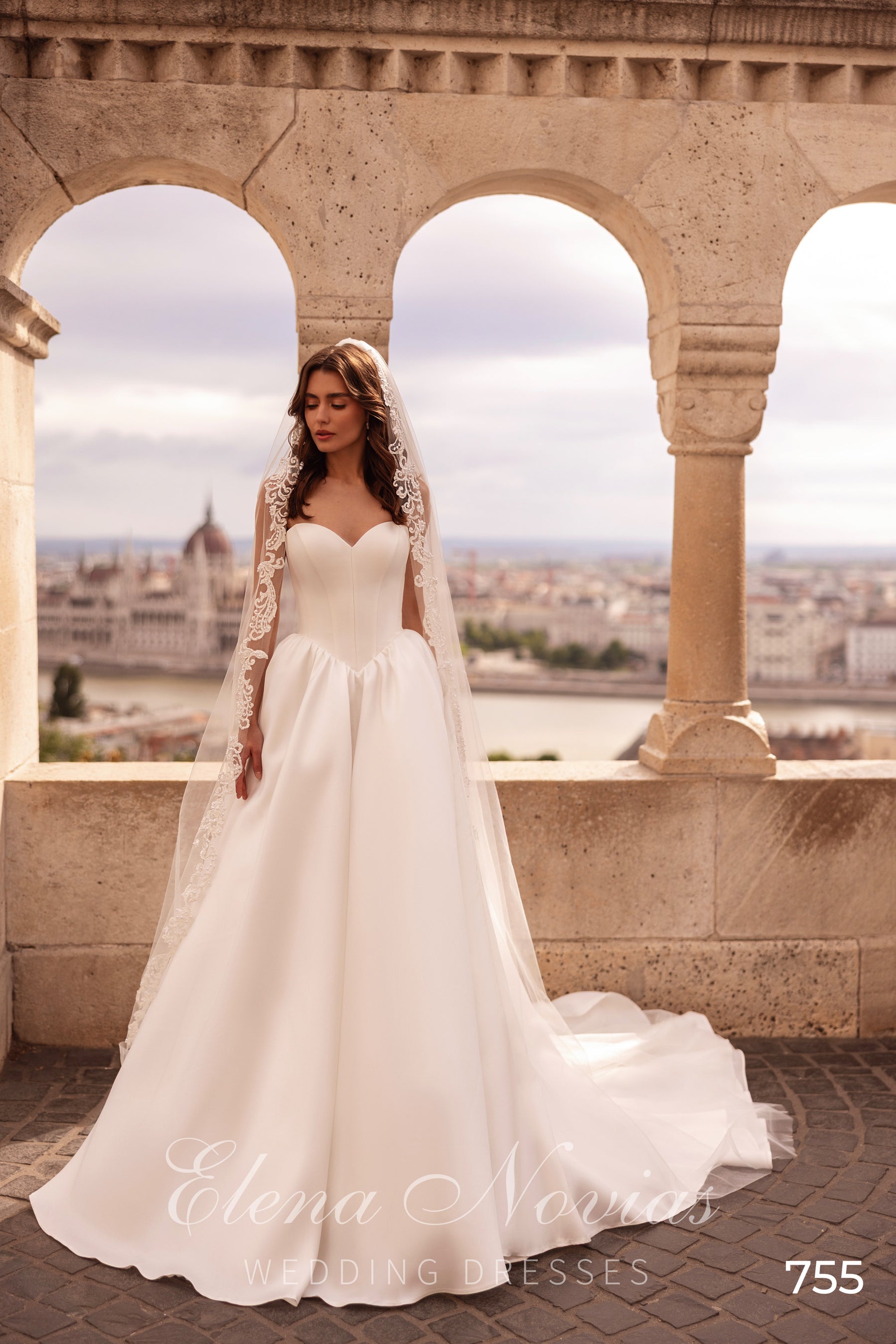 Ivory wedding dress with a sweetheart neckline, sheer lace long sleeves, and a flowing full skirt