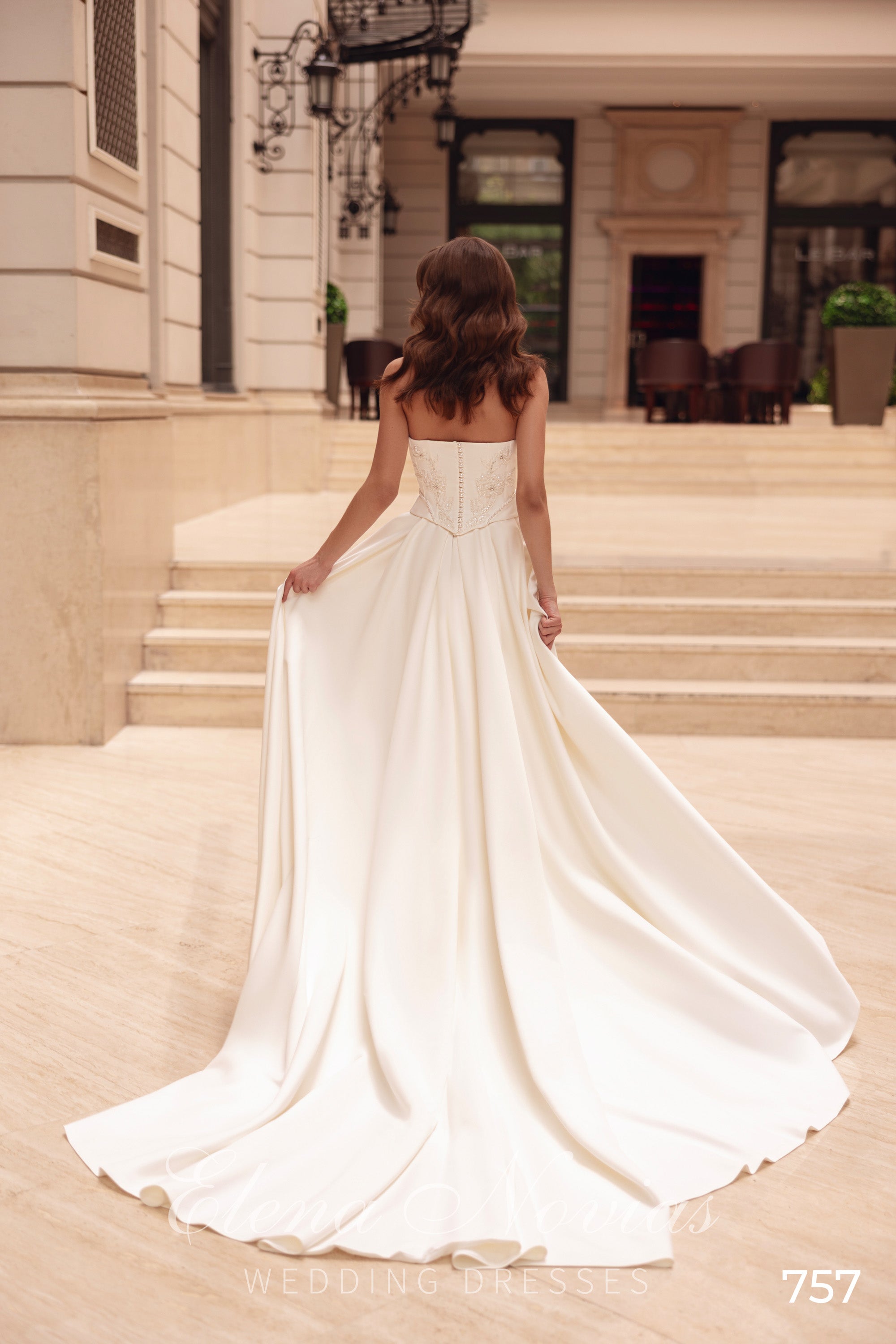 Rear view of an ivory wedding dress showing the corset-style back and flowing floor-length train