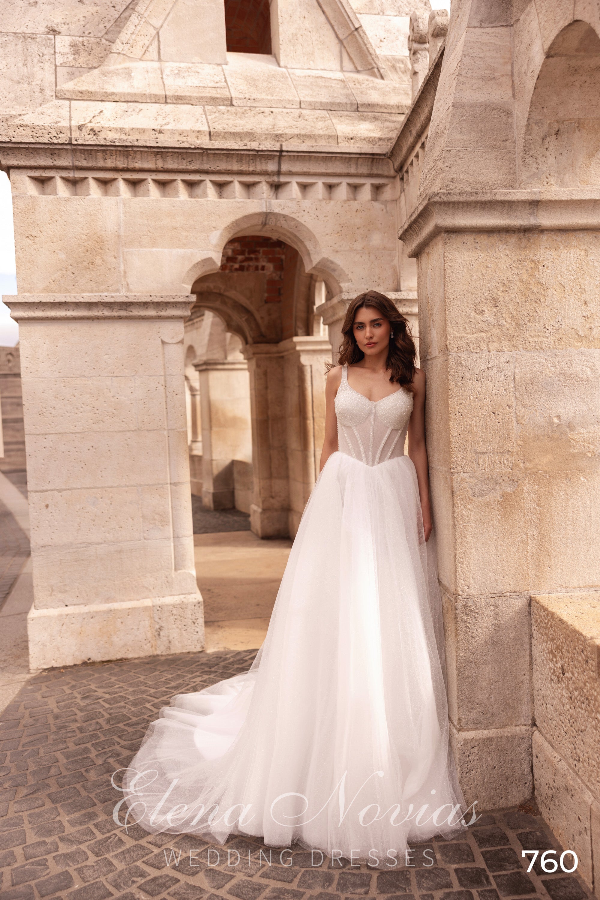 Ivory A-line wedding dress with beaded sweetheart bodice, spaghetti straps, and a flowing tulle train