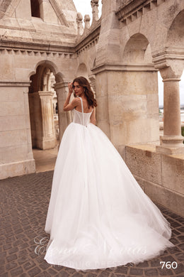 Low open-back ivory wedding dress with spaghetti straps, corset closure, and a full tulle train