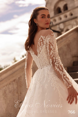 Open V-back ivory wedding dress with floral lace sleeves, beaded appliqués, and a full A-line skirt
