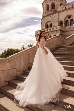 Ivory A-line wedding dress showing long lace sleeves, a flowing skirt, and a sweeping train
