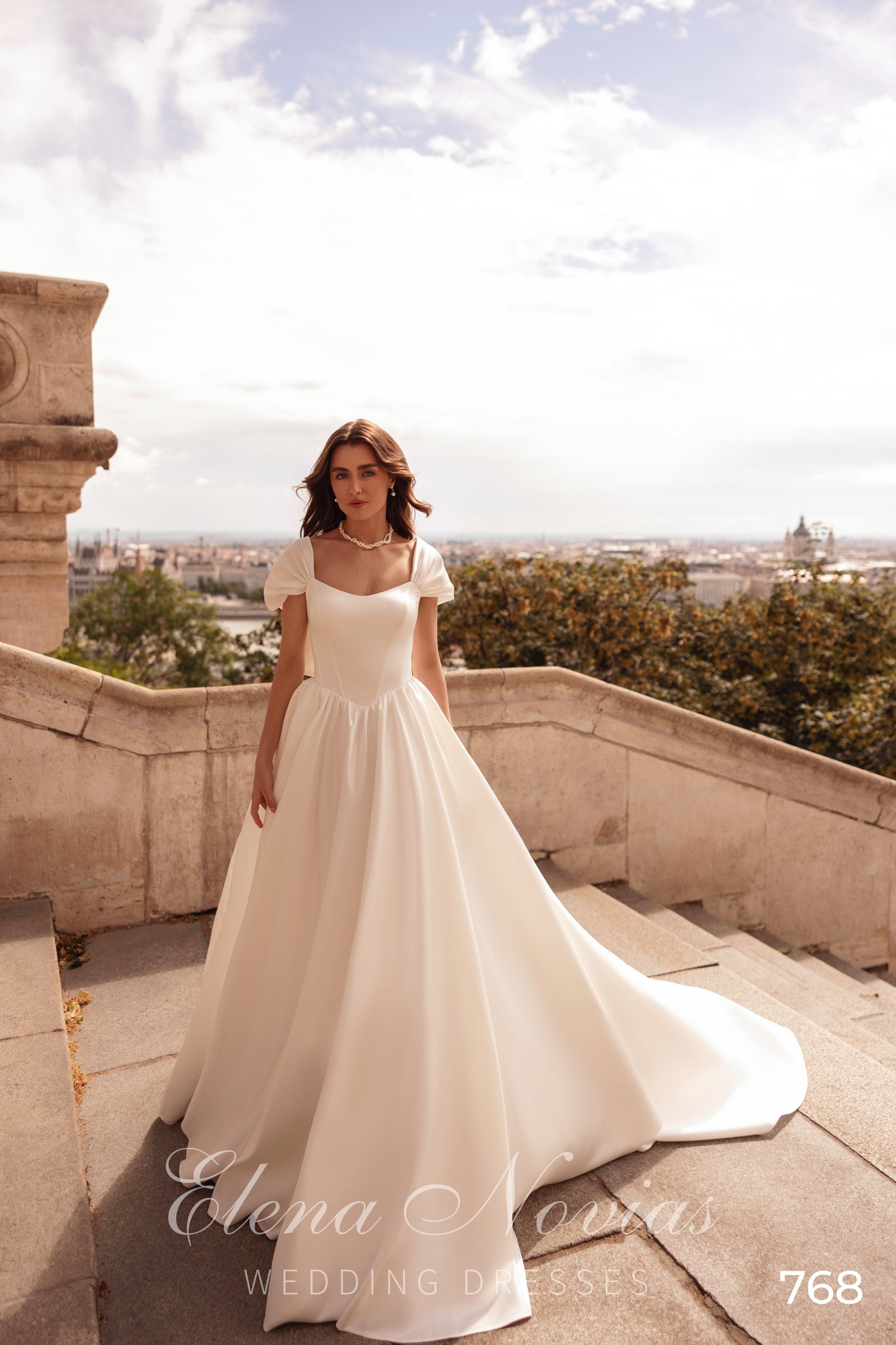 Ivory A-line wedding dress with a scoop neckline, short puff sleeves, and a flowing full skirt
