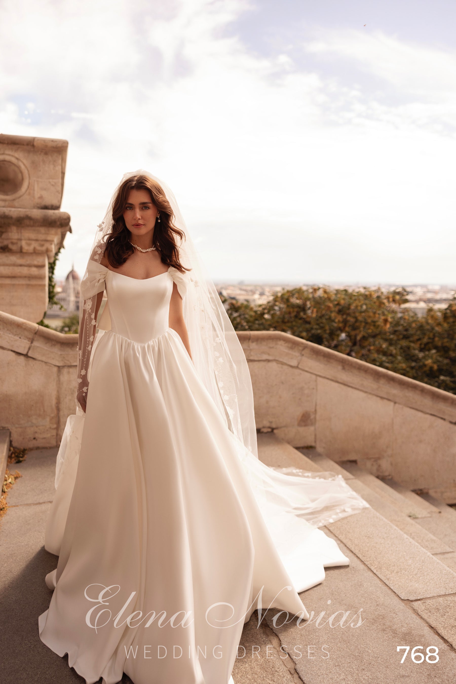 Ivory scoop-neck wedding dress with short puff sleeves, a fitted bodice, and a sweeping A-line skirt