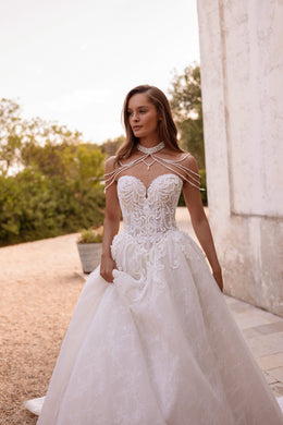 Embroidered ivory ball gown wedding dress with a sweetheart bodice, sheer beaded neckline, and full skirt