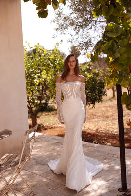 Ivory mermaid wedding dress with an off-the-shoulder neckline, sheer lace sleeves, and a sweeping train