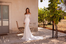 Fitted ivory wedding dress with long lace sleeves, an off-the-shoulder neckline, and a trailing mermaid skirt