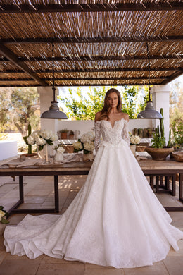 Ivory A-line wedding dress with an off-the-shoulder neckline, long lace sleeves, and a sweeping train