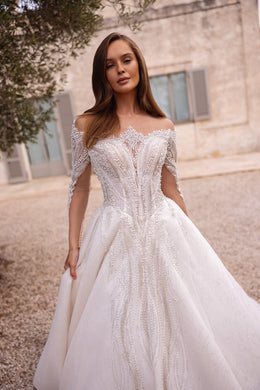 Ivory ball gown wedding dress with an off-shoulder neckline, long sheer sleeves, and sparkling beadwork