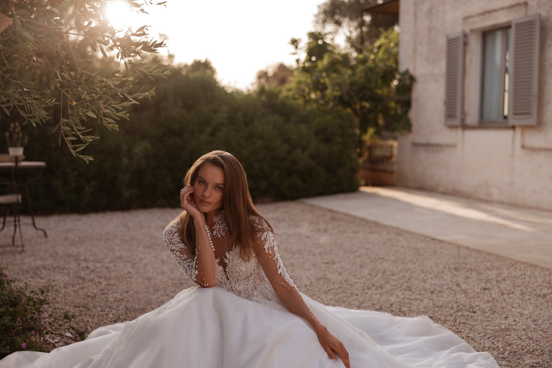 Ivory wedding dress featuring a beaded illusion bodice, long sleeves, and a voluminous flowing skirt