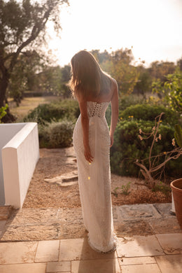 Lace-up open back on a beaded ivory wedding dress with a narrow sheath silhouette