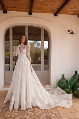 Ivory wedding dress with a fitted lace bodice and a detachable full overskirt with a sweeping train