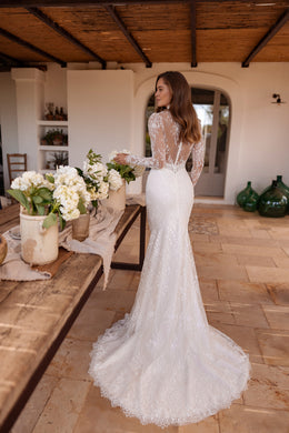 Sheer lace back and long scalloped train on an ivory fitted wedding dress