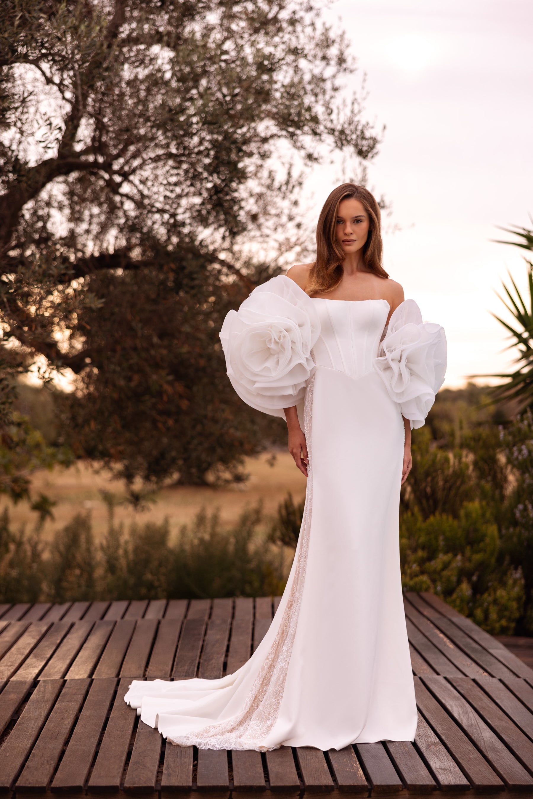 Ivory sheath wedding dress with a square neckline, oversized floral puff sleeves, and a long train
