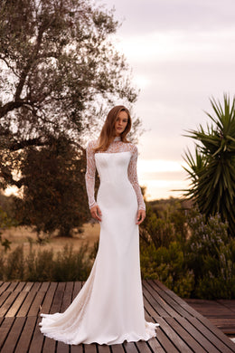 Fitted ivory wedding dress with sheer floral lace sleeves, a square neckline, and a sweeping train