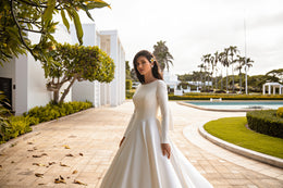 Ivory A-line wedding dress with a high bateau neckline, long sleeves, and a smooth skirt