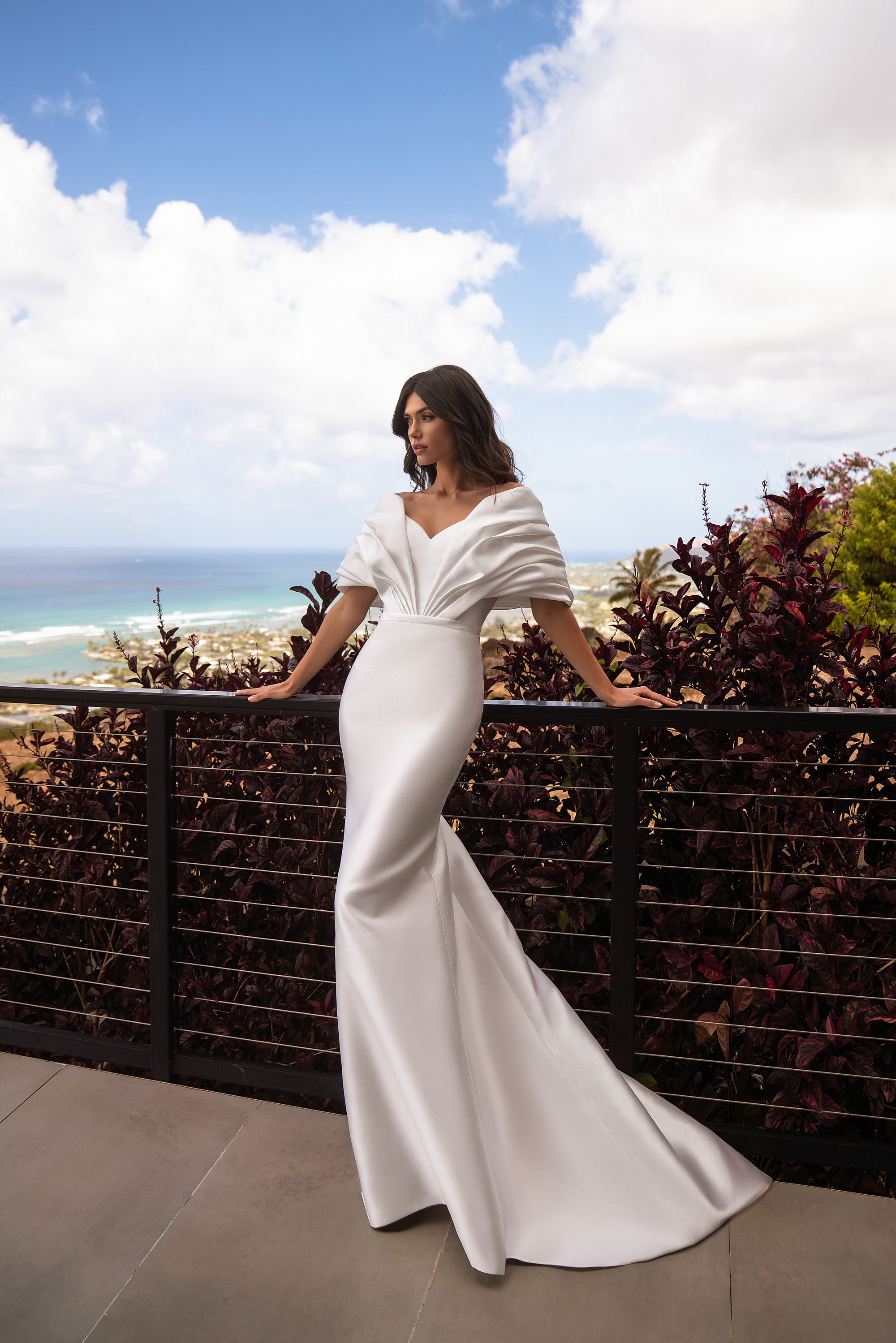 Ivory satin mermaid wedding dress with draped off-the-shoulder sleeves, V-neckline, and sweeping train