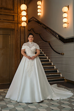 Ivory ball gown wedding dress with a lace bodice, short sleeves, and a sweeping train