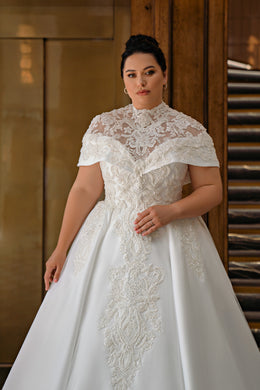 Close-up of floral lace detailing and a high neckline on an ivory wedding dress bodice