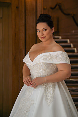 Off-the-shoulder wedding dress with an embellished lace bodice and full ball gown skirt