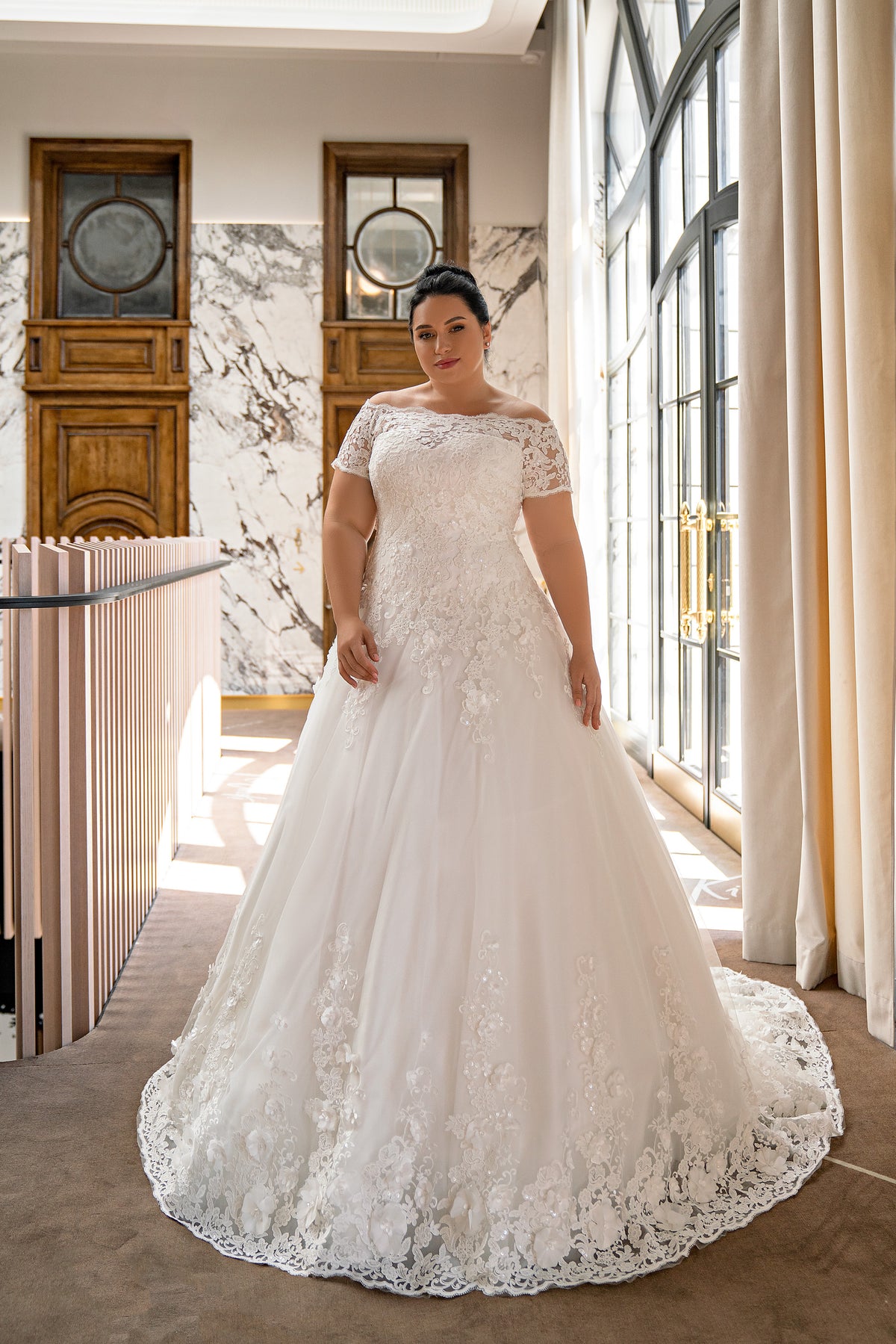 Ivory ball gown wedding dress with an off-the-shoulder lace neckline, short sleeves, floral appliqués, and a sweeping train