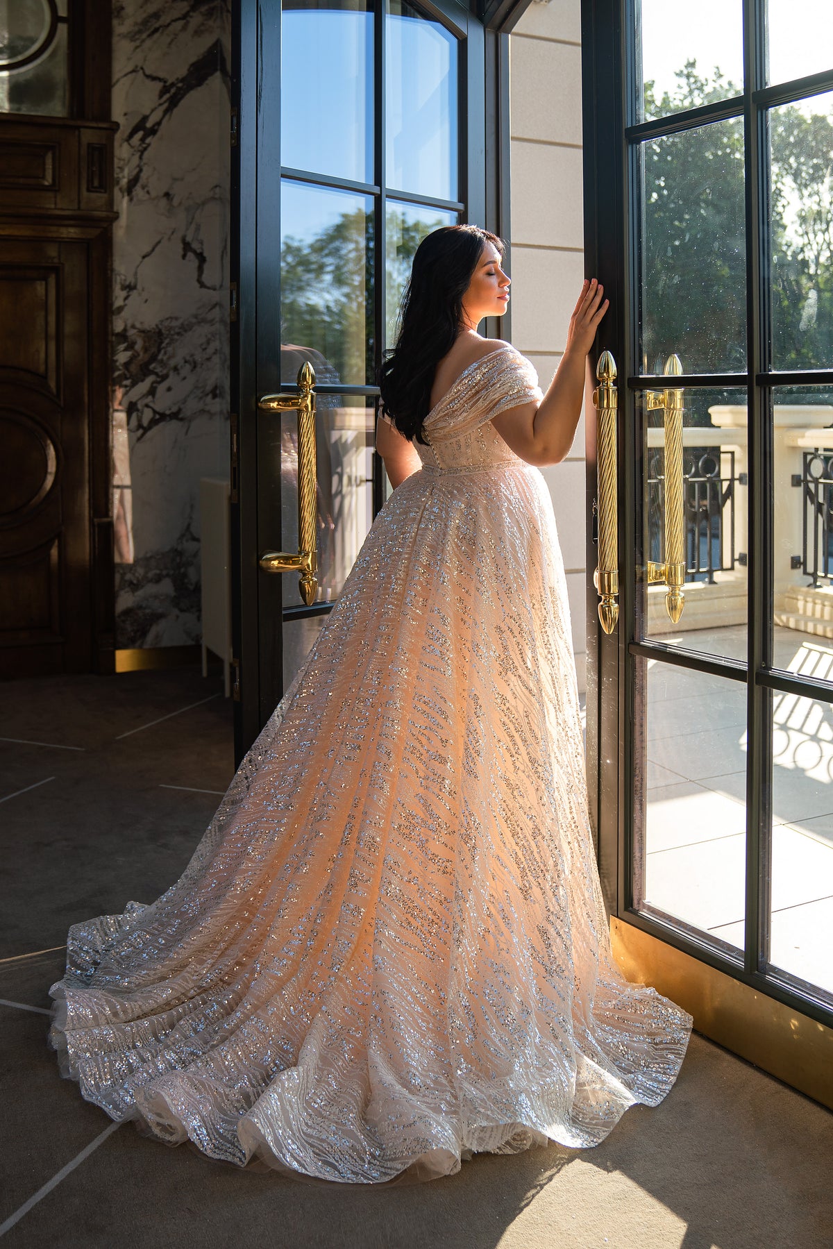 Beaded champagne wedding dress with an off-the-shoulder neckline, fitted silhouette, and long scalloped train