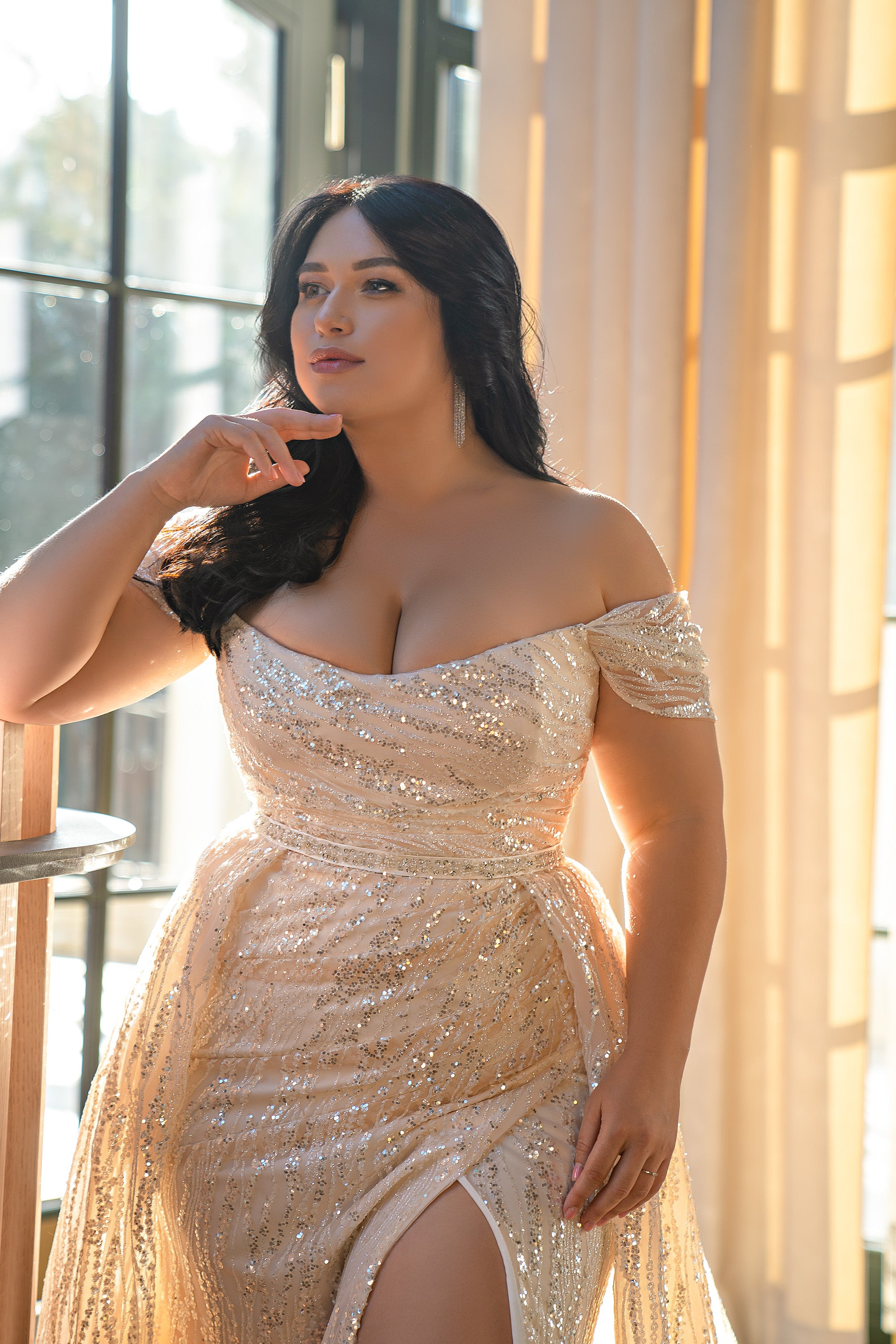 Close-up of a wedding dress with an off-the-shoulder neckline, draped beading, and thigh-high slit