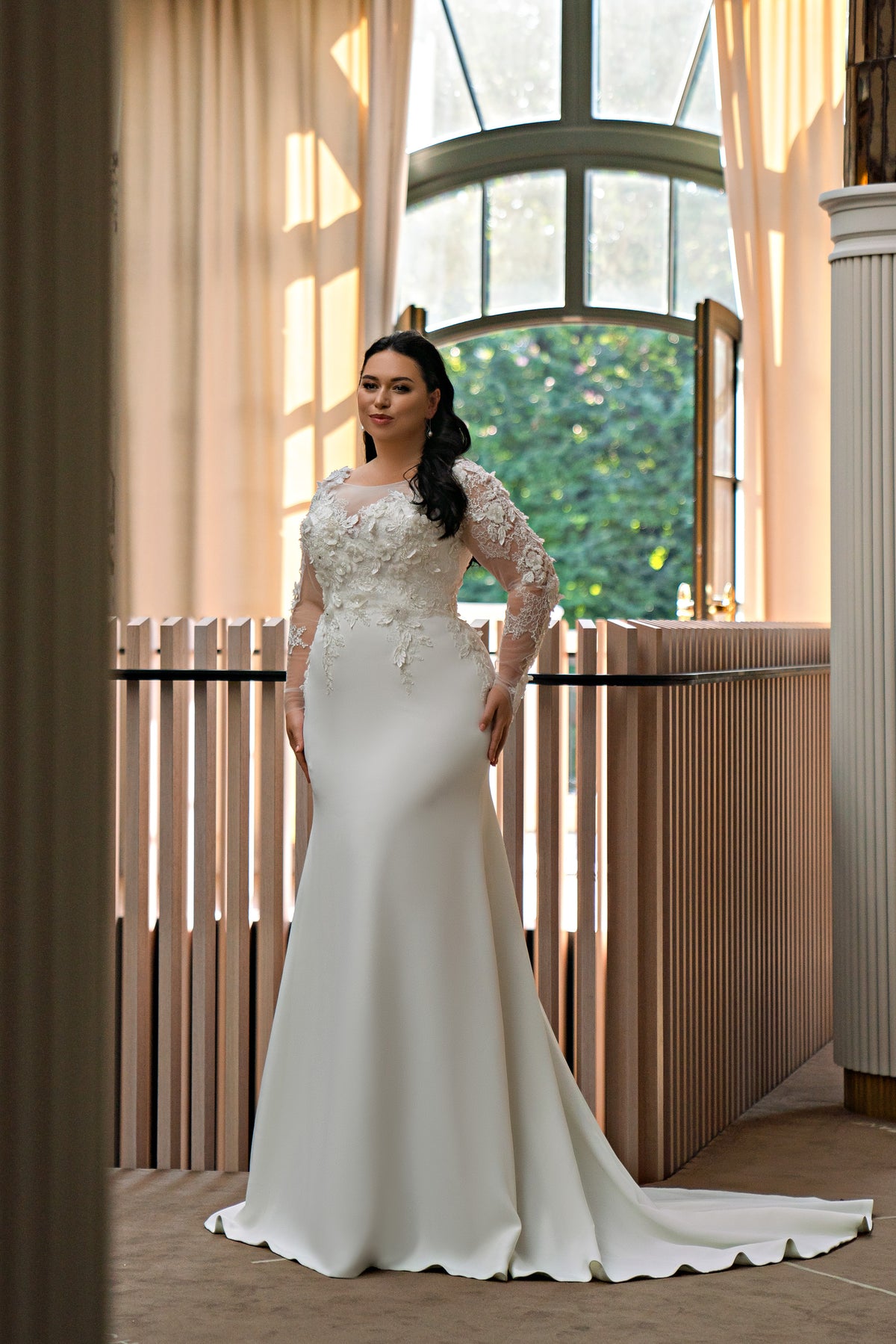 Ivory trumpet wedding dress with long illusion lace sleeves, floral appliqués, and a sweeping train