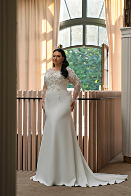 Ivory trumpet wedding dress with long illusion lace sleeves, floral appliqués, and a sweeping train