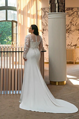 Ivory wedding dress with an illusion lace back, long lace sleeves, fitted trumpet skirt, and train