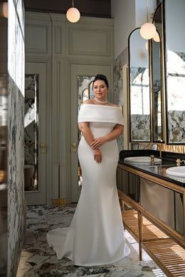 Ivory mermaid wedding dress with a draped off-shoulder neckline, short sleeves, and long train