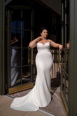 Ivory mermaid wedding dress with a sweetheart neckline, fitted bodice, and sweeping floor-length train