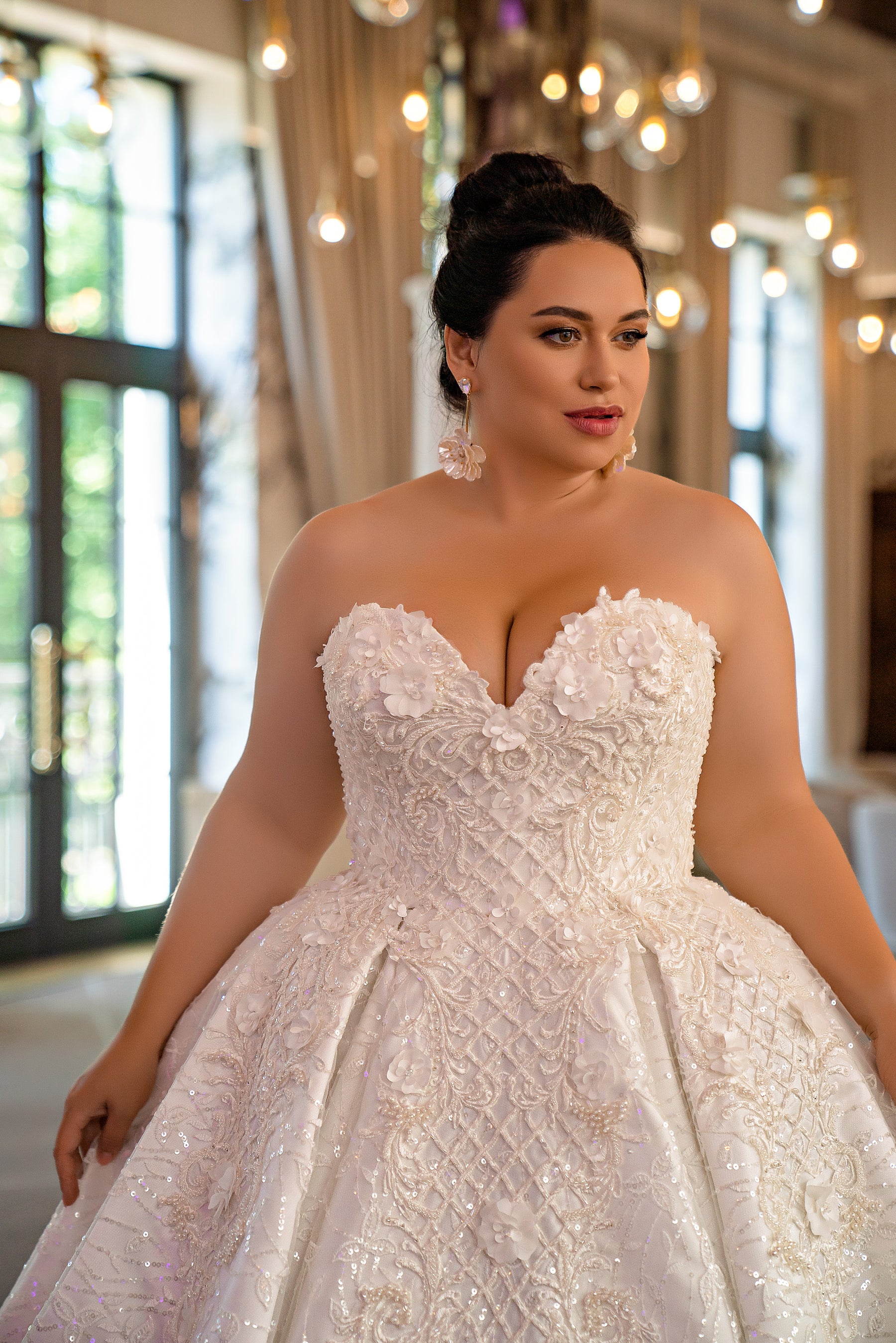 Close-up of an ivory wedding dress with a sweetheart neckline, floral appliqués, and beaded embroidery