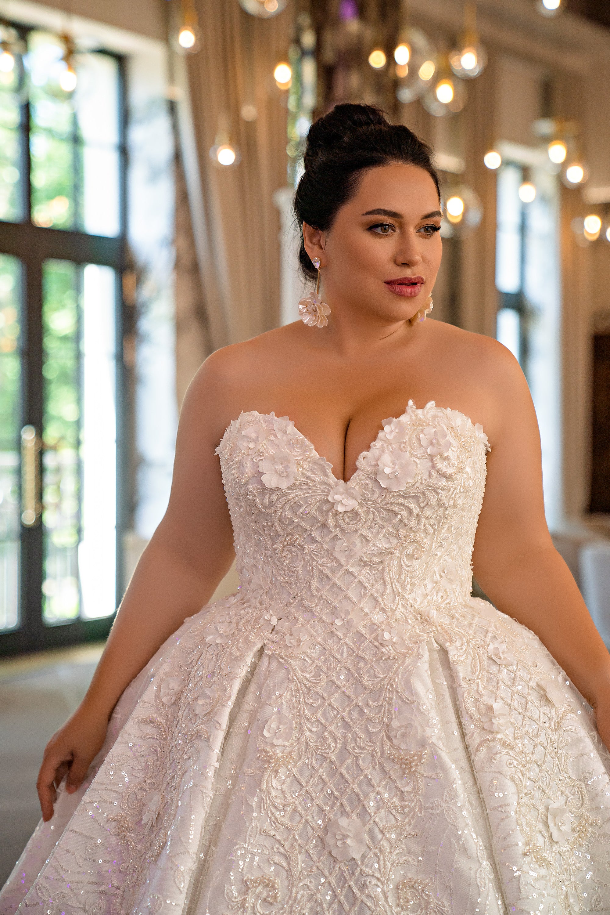 Close-up of an ivory wedding dress with a sweetheart neckline, floral appliqués, and beaded embroidery