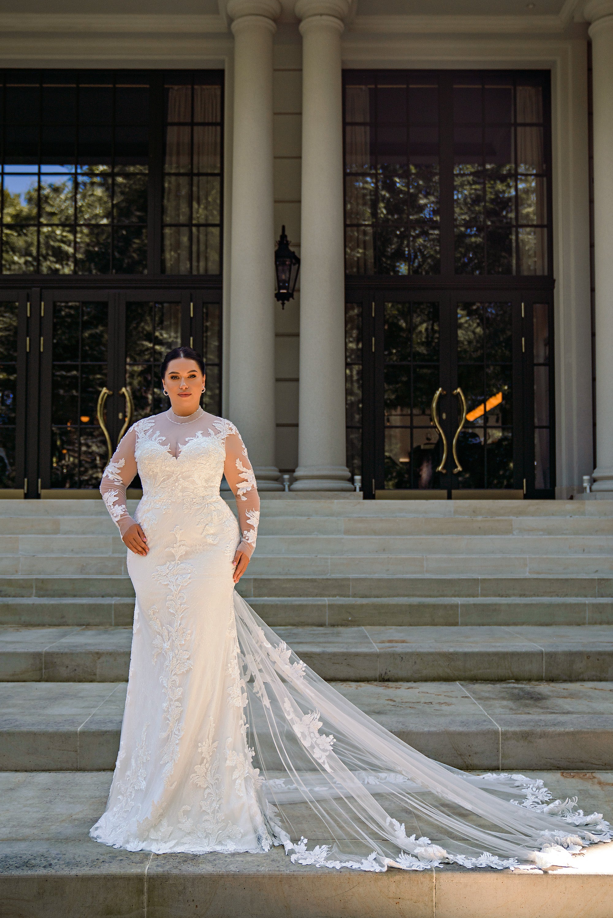 Ivory mermaid wedding dress with long illusion lace sleeves, floral appliqués, and a sweeping train