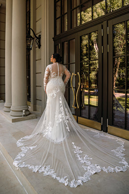 Lace-covered back and dramatic floral-edged train on an ivory mermaid wedding dress